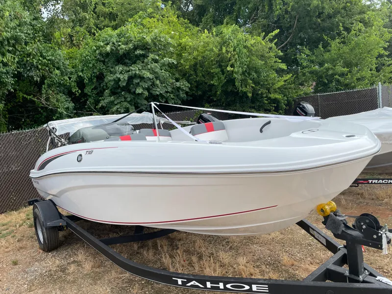 Slide: The Image of 2024 Tahoe T18 boat on trailer, white with red accents, parked outdoors. - 3