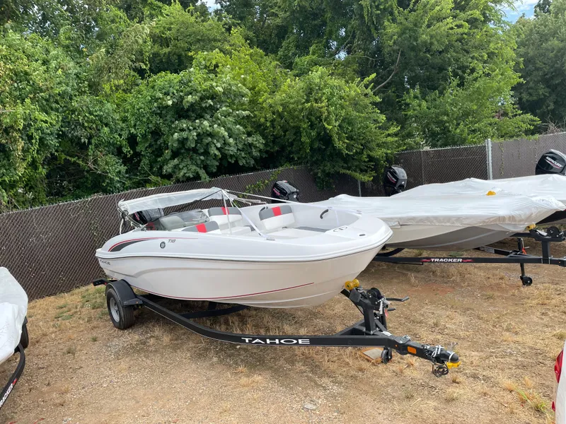 Slide: The Image of 2024 Tahoe T18 boat on trailer, parked outdoors near trees. - 5