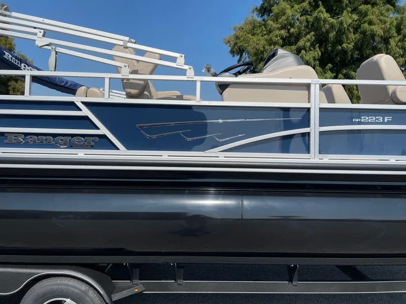 Slide: The Image of 2024 Ranger Reata 223F pontoon boat with blue and white exterior. - 6