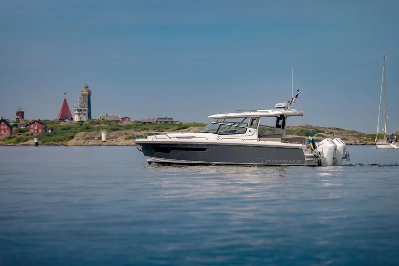 Slide: The Image of 2024 Nimbus Weekender 11 boat cruising near scenic coastal landscape. - 40