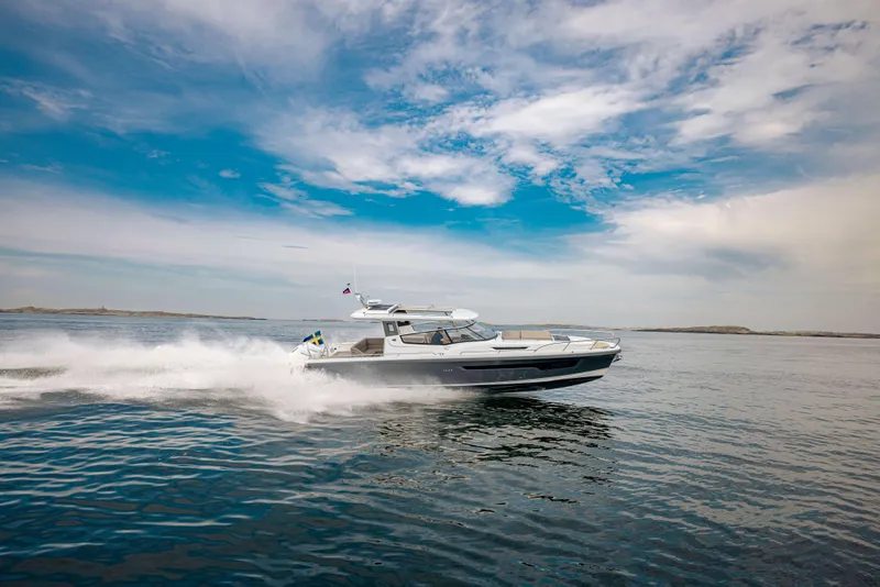 Slide: The Image of 2024 Nimbus Weekender 11 cruising on open water under a blue sky. - 46