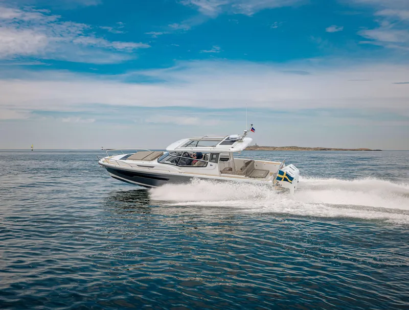 Slide: The Image of 2024 Nimbus Weekender 11 cruising on open water under a clear blue sky. - 47