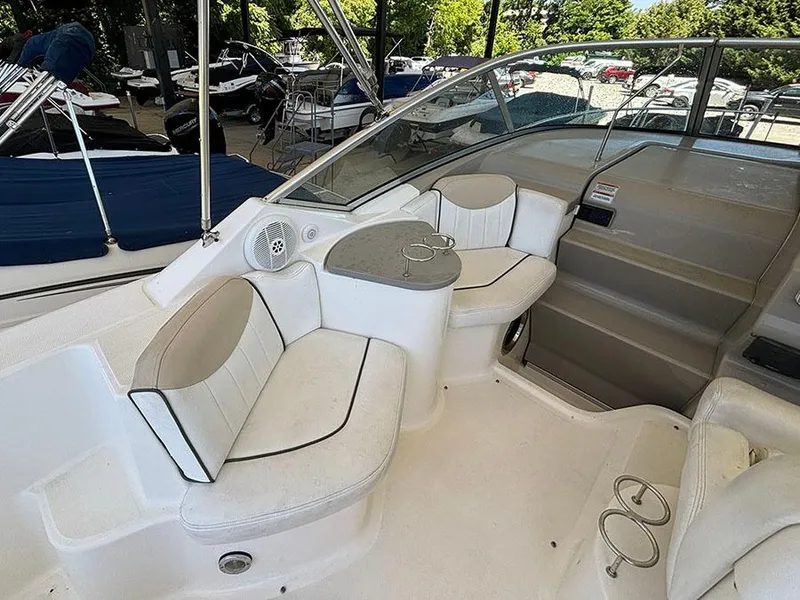 Slide: The Image of 2008 Sea Ray 240 Sundancer boat interior with white seating and table. - 12