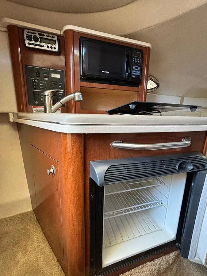 Slide: The Image of 2008 Sea Ray 240 Sundancer galley with microwave, sink, and mini-fridge. - 18