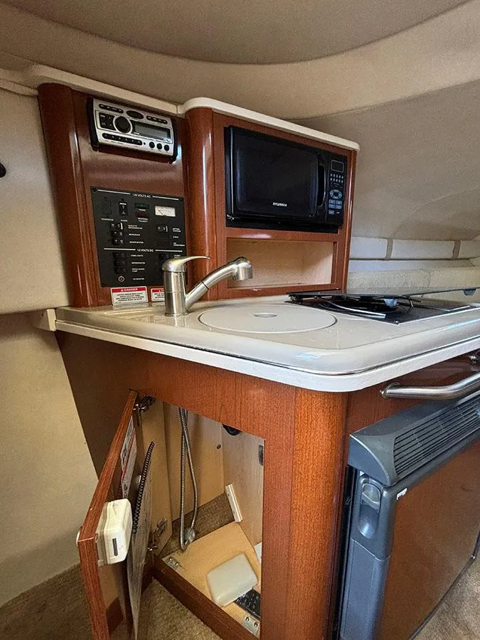 Slide: The Image of 2008 Sea Ray 240 Sundancer galley with microwave, sink, and storage. - 19