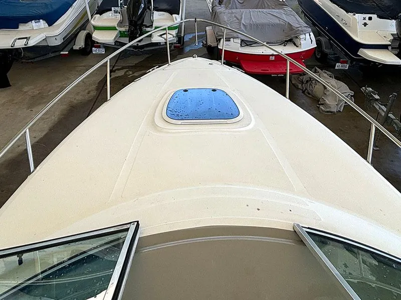 Slide: The Image of 2008 Sea Ray 240 Sundancer boat bow view in storage with hatch window. - 5