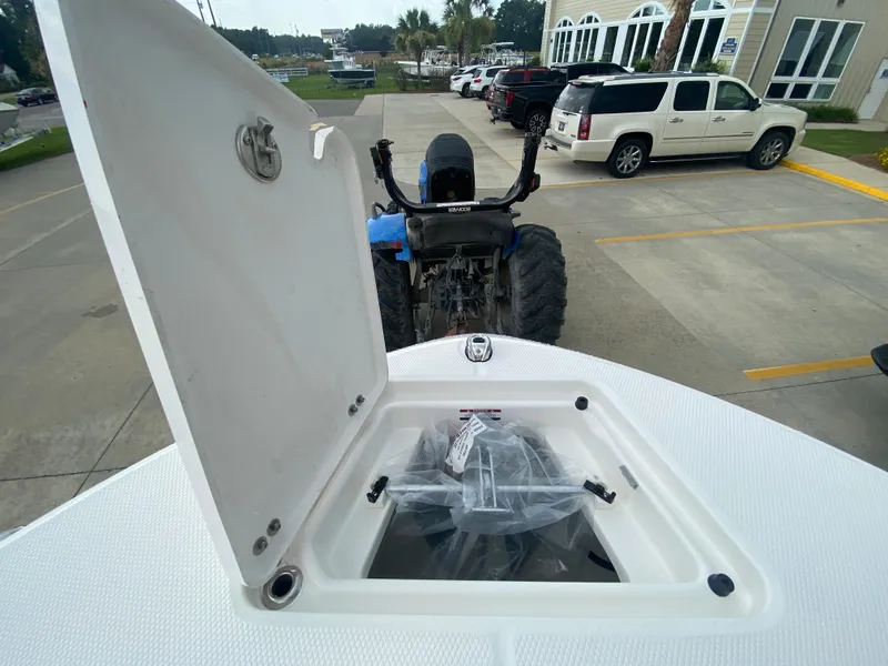 Slide: The Image of Open hatch on 2026 Robalo 202 EXPLORER boat, parked near vehicles and tractor. - 23