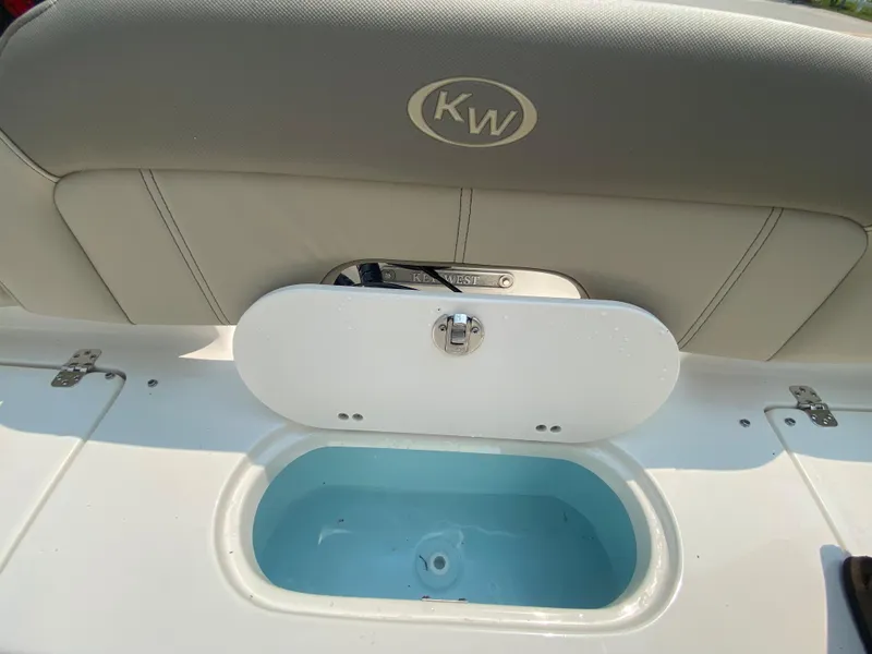 Slide: The Image of Key West 203 FS 2026 boat seat with storage compartment, open lid, and KW logo. - 10