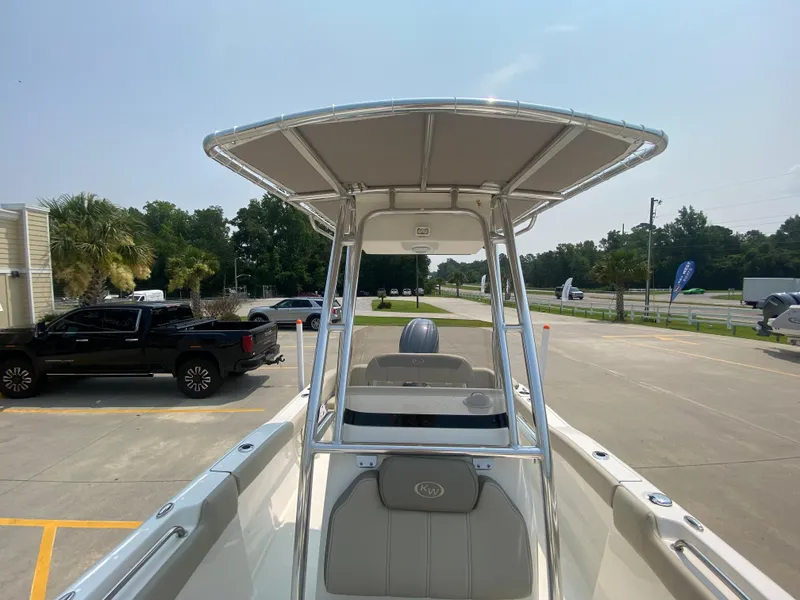 Slide: The Image of 2026 Key West 203 FS boat with T-top, parked in a lot under clear skies. - 23