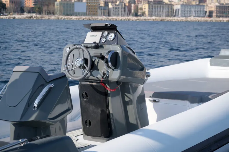 Slide: The Image of Custom Sunrise 24 boat console, 2024 model, on calm sea with cityscape background. - 10