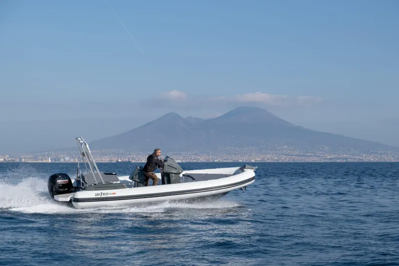 Slide: The Image of Custom Sunrise 24 boat cruising on water with mountain backdrop, 2024 model. - 2