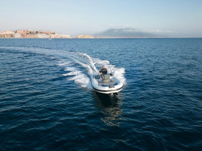 Slide: The Image of Custom Sunrise 24 boat cruising on open sea, 2024 model, with coastal city in background. - 8