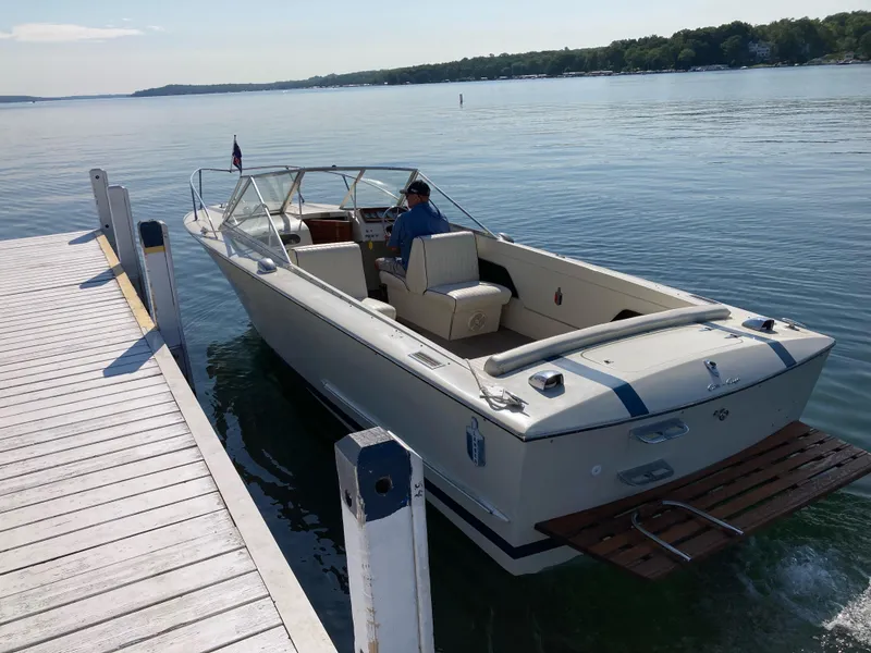 Slide: The Image of 1970 Chris-Craft Lancer 23 boat docked on a serene lake. - 10