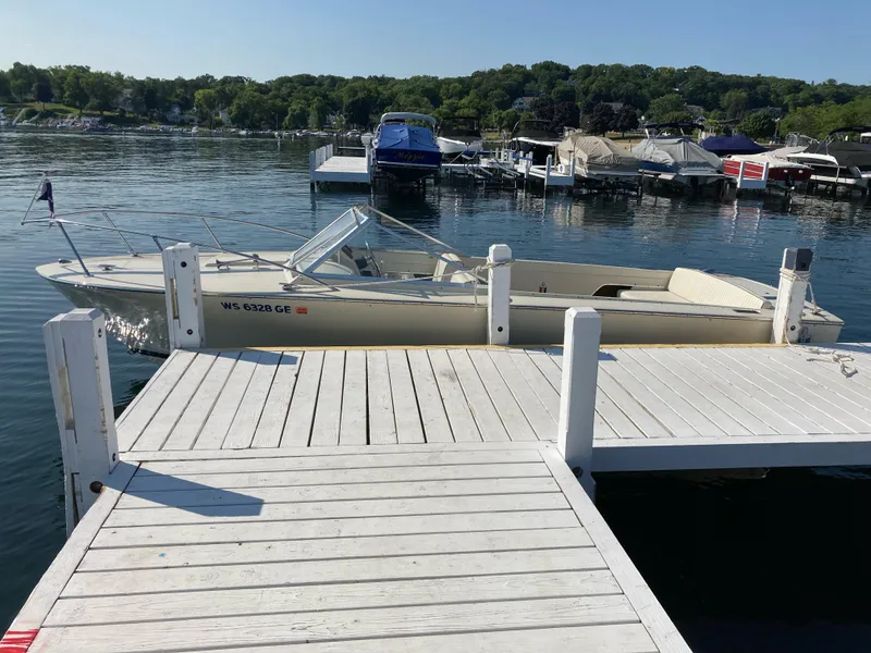 Slide: The Image of 1970 Chris-Craft Lancer 23 docked at a serene marina. - 12