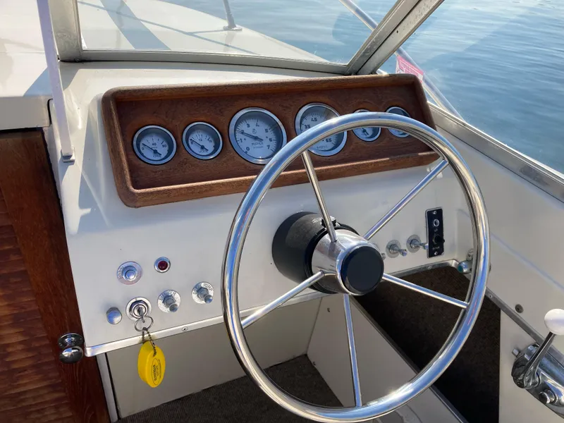 Slide: The Image of 1970 Chris-Craft Lancer 23 boat dashboard with steering wheel and gauges. - 14