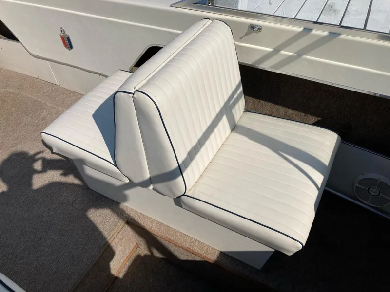 Slide: The Image of 1970 Chris-Craft Lancer 23 boat seat with white upholstery and black piping. - 17