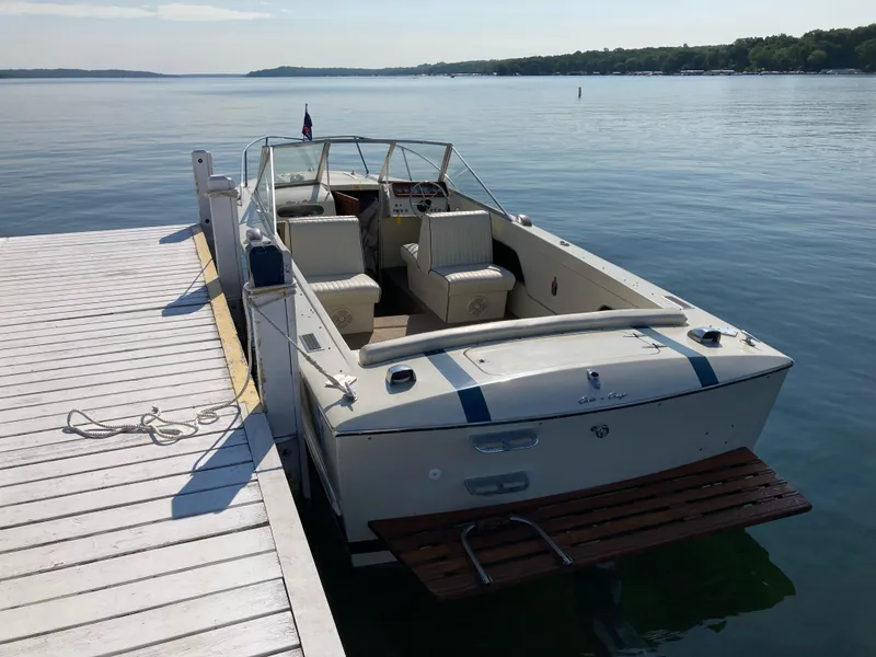 Slide: The Image of 1970 Chris-Craft Lancer 23 boat docked on a serene lake. - 8