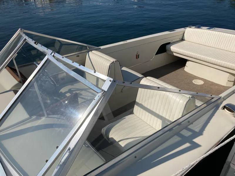 Slide: The Image of 1970 Chris-Craft Lancer 23 boat with white interior on calm water. - 9