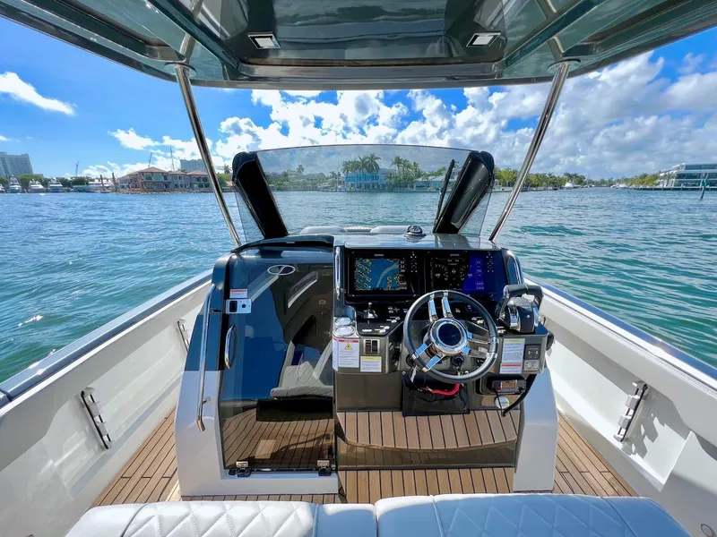 Slide: The Image of Cockpit view of 2025 Schaefer V33 boat with modern controls and scenic waterfront. - 12