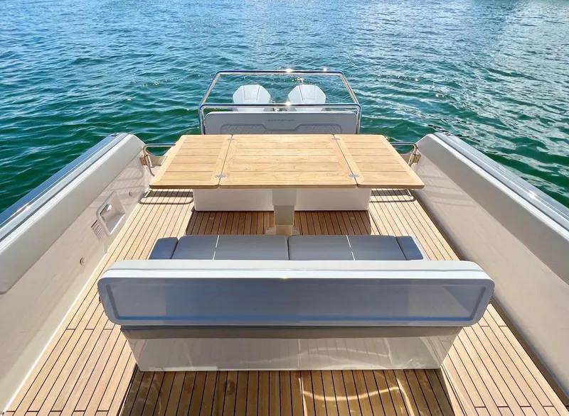 Slide: The Image of Schaefer V33 2025 boat with teak deck and seating area on water. - 17