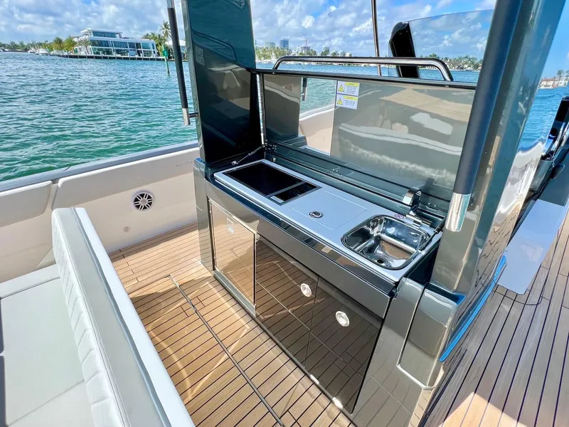 Slide: The Image of Schaefer V33 2025 yacht with outdoor kitchen, sink, and seating area on deck. - 15