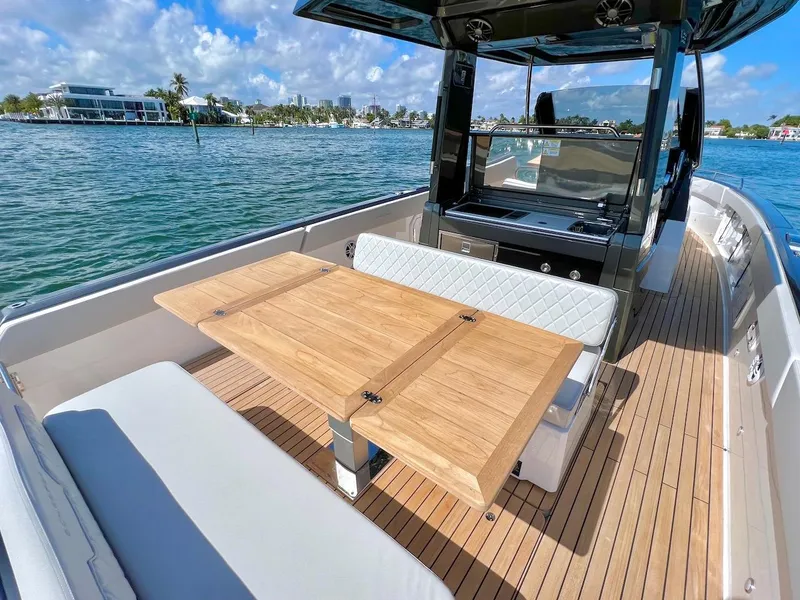 Slide: The Image of Luxury Schaefer V33 2025 yacht interior with wooden table and waterfront view. - 21