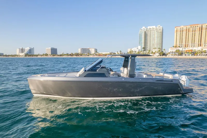 Slide: The Image of 2025 Schaefer V33 boat cruising near a coastal city skyline. - 33