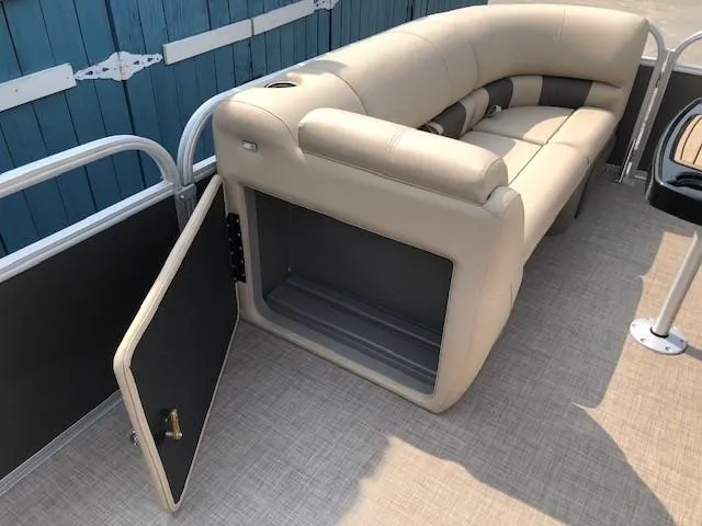 Slide: The Image of 2023 Sun Tracker Party Barge 22 DLX with open storage compartment under beige seating. - 11
