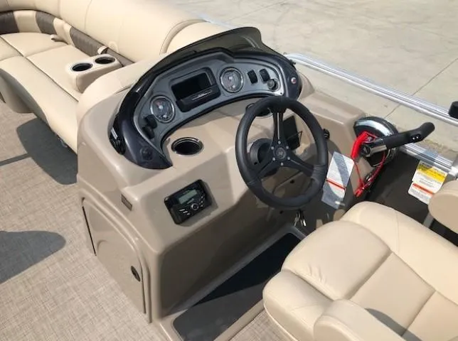 Slide: The Image of 2023 Sun Tracker Party Barge 22 DLX helm with beige seating and control panel. - 12