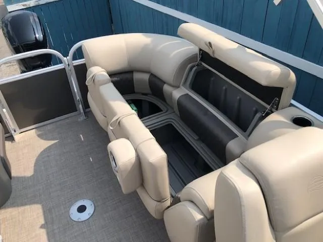 Slide: The Image of 2023 Sun Tracker Party Barge 22 DLX interior with beige seating and storage compartments. - 19