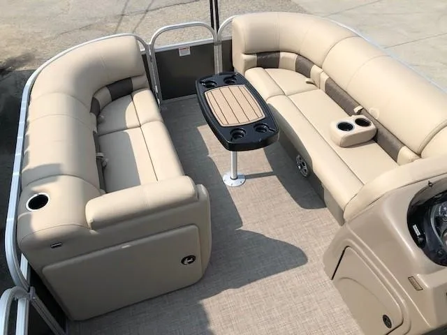 Slide: The Image of 2023 Sun Tracker Party Barge 22 DLX interior with beige seating and central table. - 6