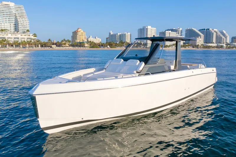 The Image of 2025 Schaefer V33 boat cruising near a coastal city skyline. - 0