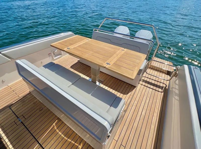Slide: The Image of Schaefer V33 2025 boat with teak deck, foldable table, and cushioned seating. - 20