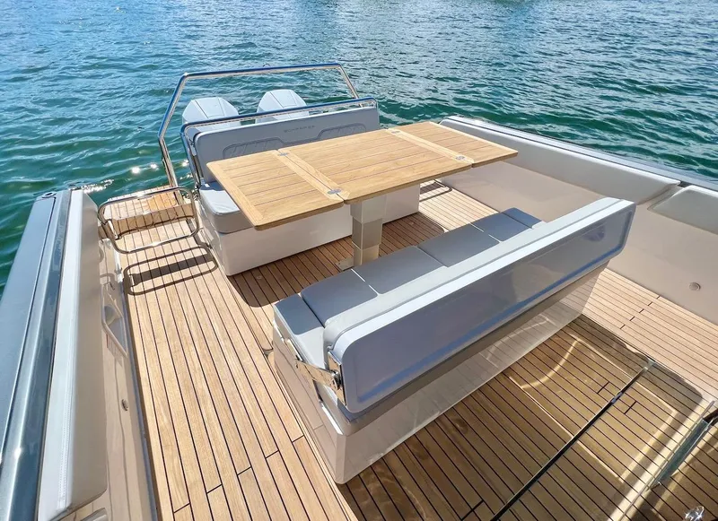 Slide: The Image of Schaefer V33 2025 boat with teak deck, seating area, and wooden table on water. - 22