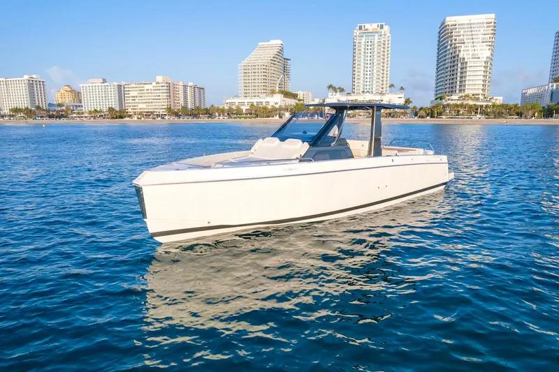 Slide: The Image of Schaefer V33 2025 boat cruising near a coastal city skyline. - 1
