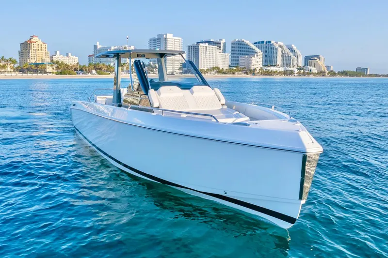 Slide: The Image of 2025 Schaefer V33 boat cruising near a coastal city skyline. - 10