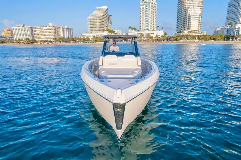 Slide: The Image of Schaefer V33 2025 boat cruising near a city skyline on a sunny day. - 11