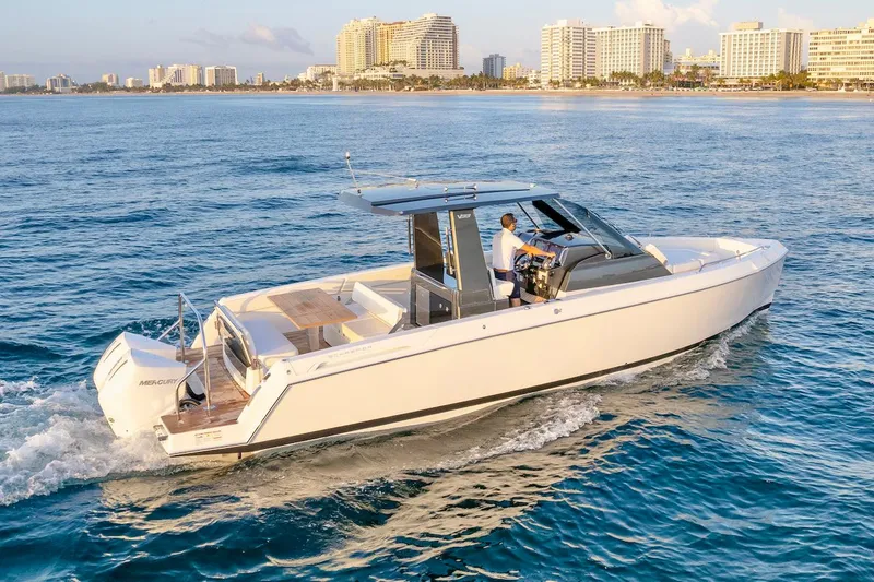 Slide: The Image of 2025 Schaefer V33 boat cruising near a coastal city skyline. - 6