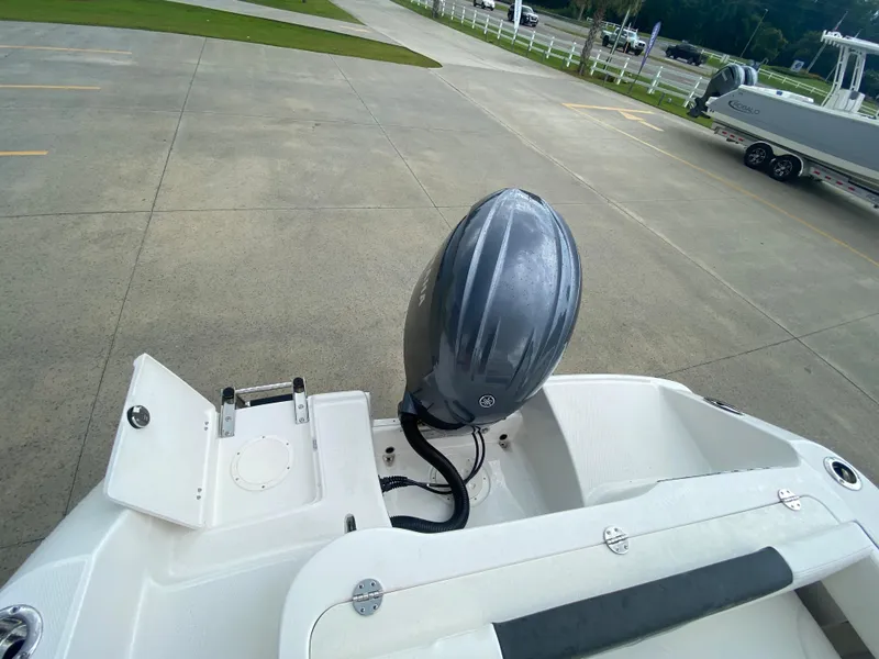 Slide: The Image of 2024 Robalo 202 EXPLORER boat with outboard motor in a parking lot. - 6