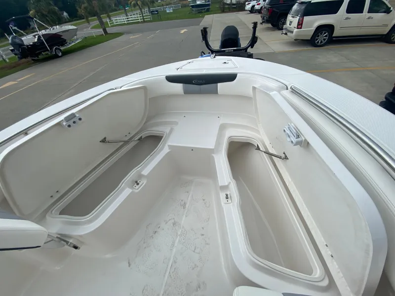 Slide: The Image of 2024 Robalo 202 EXPLORER boat with open storage compartments on deck. - 19