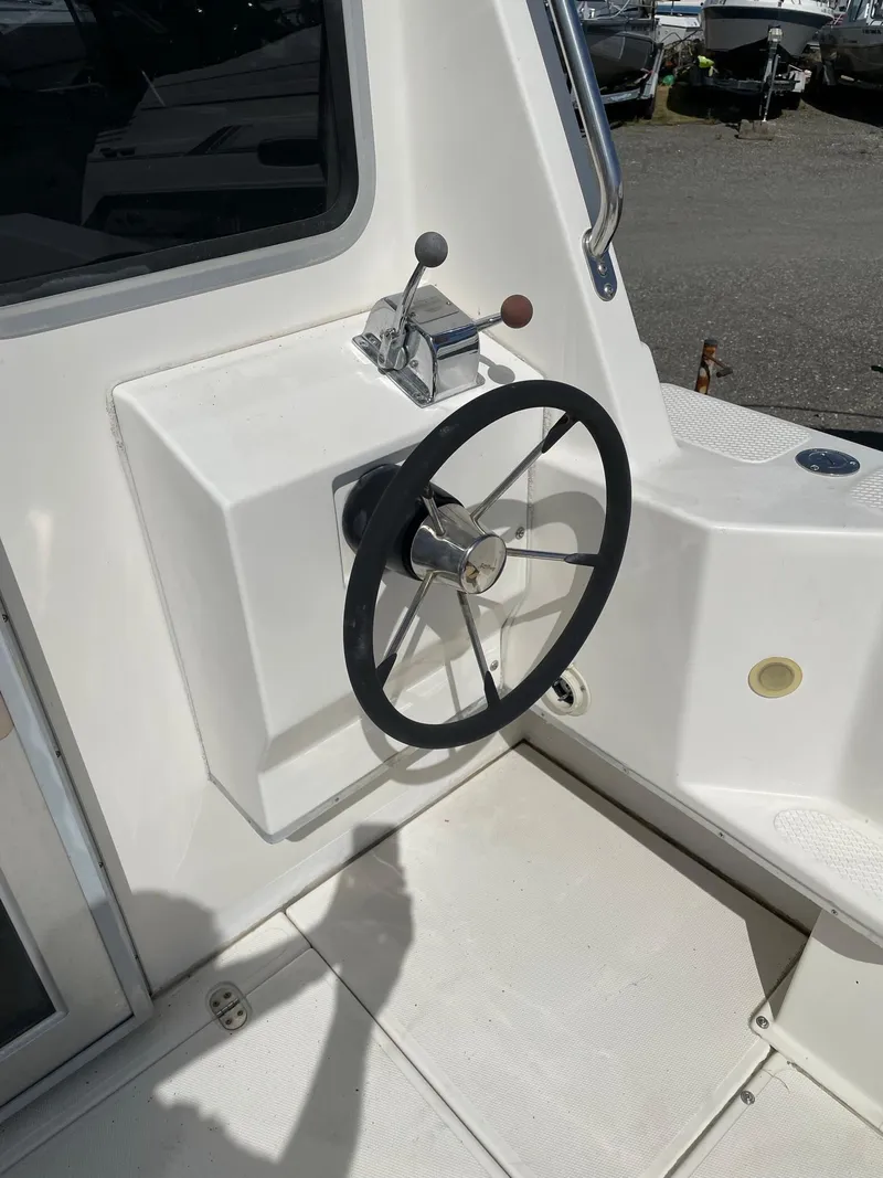 Slide: The Image of 2004 SeaSport 2400 XL boat steering wheel and throttle controls. - 10