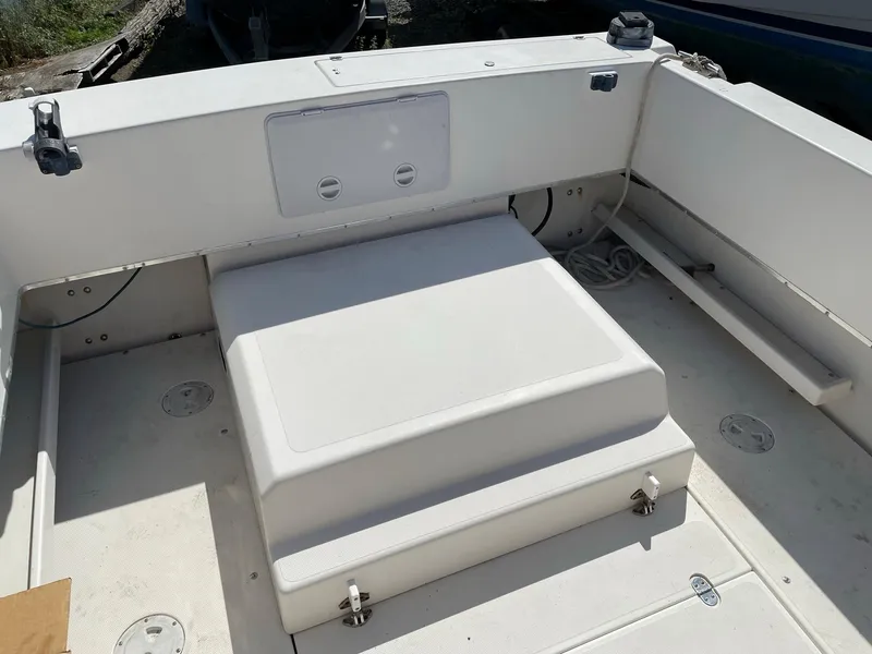 Slide: The Image of 2004 SeaSport 2400 XL boat interior, white seating and storage area. - 11