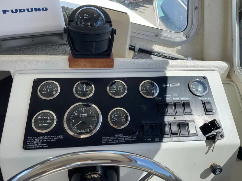 Slide: The Image of Dashboard of a 2004 SeaSport 2400 XL boat with gauges and controls. - 16