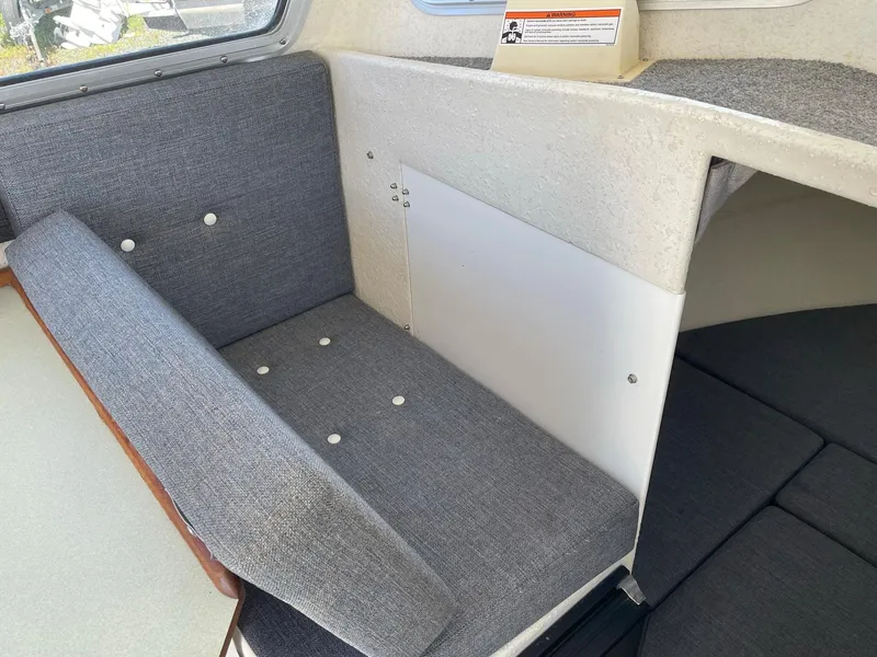 Slide: The Image of 2004 SeaSport 2400 XL interior seating area with gray upholstery. - 18