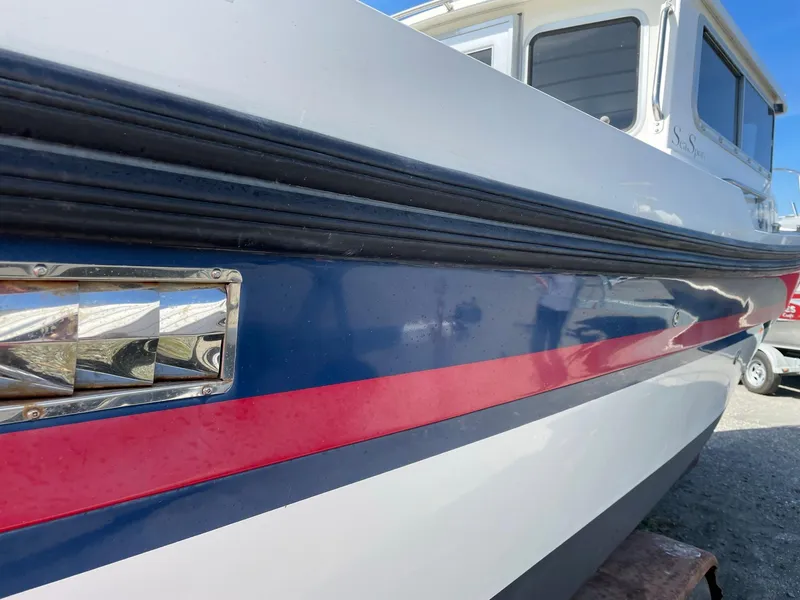 Slide: The Image of 2004 SeaSport 2400 XL boat with blue and red stripe detail. - 2