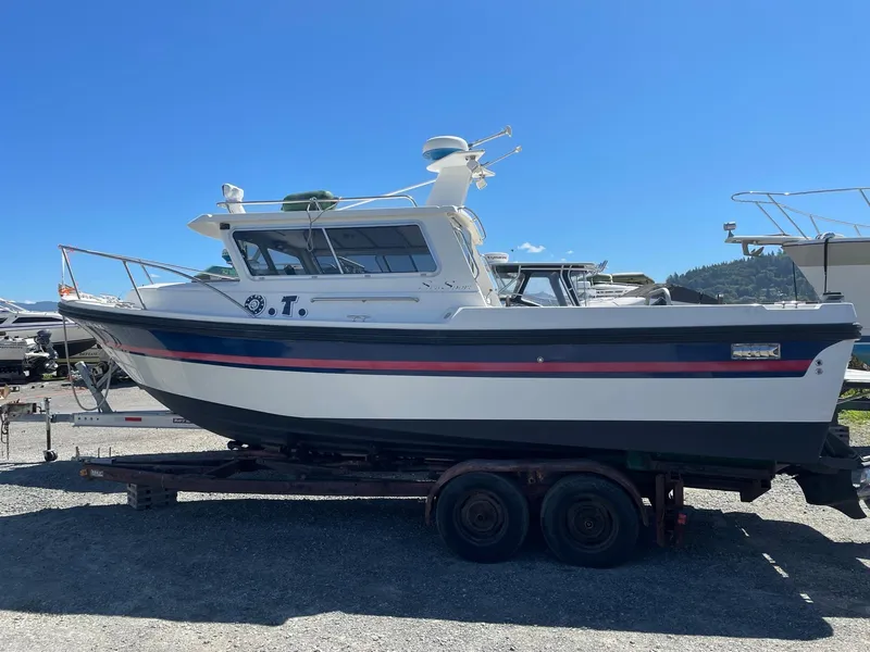 Slide: The Image of 2004 SeaSport 2400 XL boat on a trailer under clear blue sky. - 20