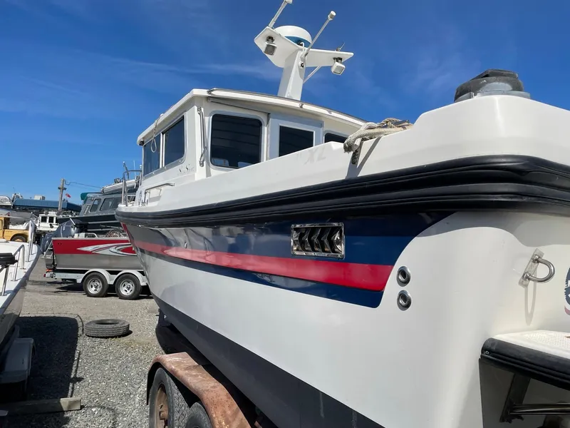 Slide: The Image of 2004 SeaSport 2400 XL boat on trailer under clear blue sky. - 3