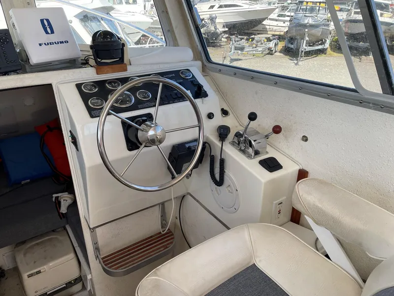 Slide: The Image of 2004 SeaSport 2400 XL boat cockpit with steering wheel and control panel. - 9