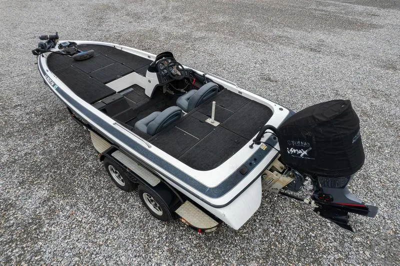 Slide: The Image of 2004 Skeeter ZX225 bass boat on a trailer, gravel background. - 2