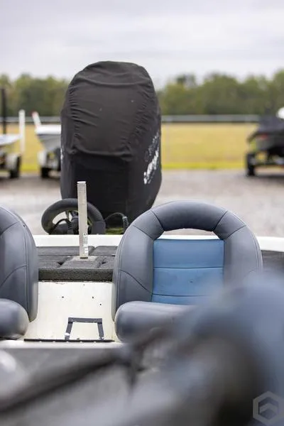 Slide: The Image of 2004 Skeeter ZX225 bass boat with covered outboard motor and dual seats. - 5